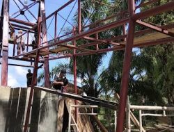 TNI dan Warga Gotong Royong Merakit Rangka Besi serta Mengecat Dasar Tiang Jembatan Perintis