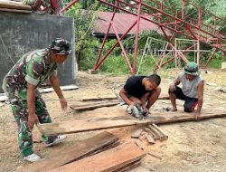 Personel TNI dan Warga Potong Bahan Papan Lantai Jembatan Perintis